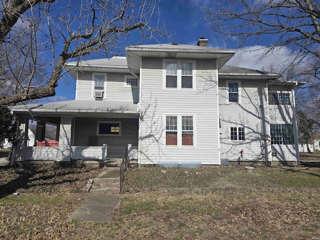 back of house with a porch, cooling unit, and a chimney