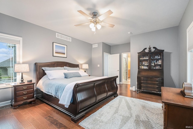 bedroom featuring dark wood-style floors, visible vents, and a ceiling fan