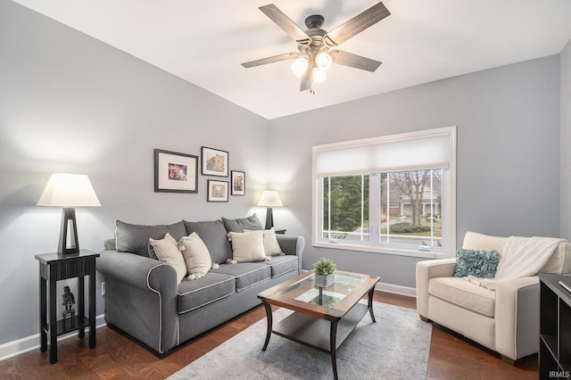 living area featuring ceiling fan, baseboards, and dark wood finished floors