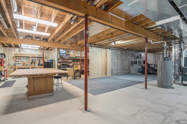 unfinished below grade area featuring a workshop area, gas water heater, and heating unit