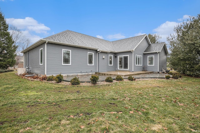 view of front of home with a front lawn, roof with shingles, and a patio area