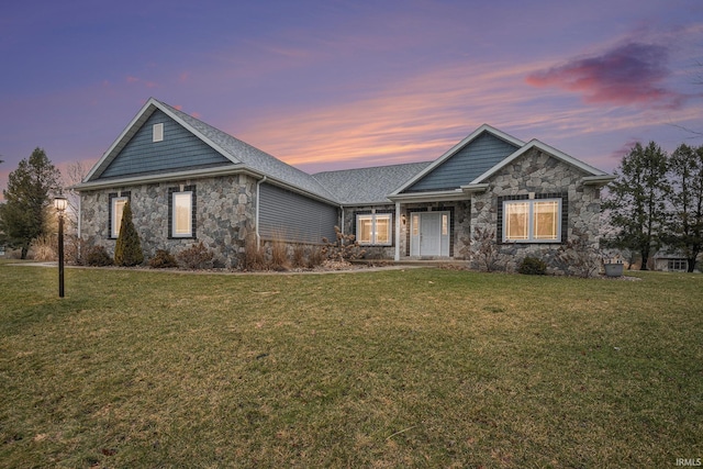 view of front of home featuring stone siding and a front lawn