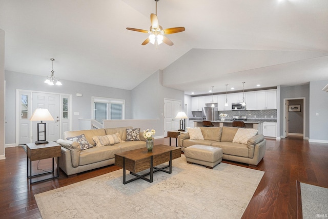 living area with dark wood-type flooring, high vaulted ceiling, baseboards, and ceiling fan with notable chandelier