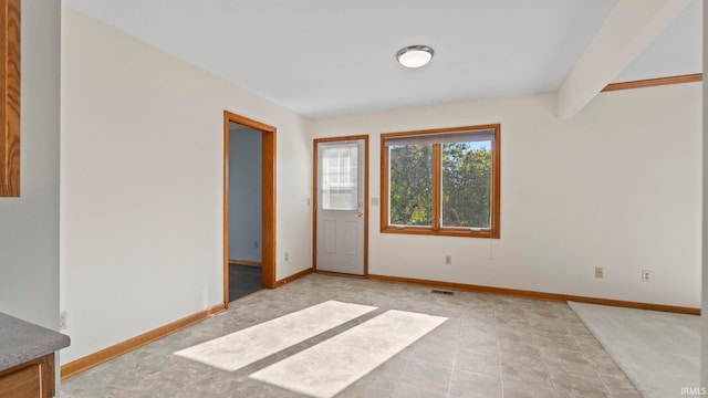 empty room featuring visible vents and baseboards