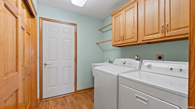 washroom with washer and clothes dryer, light wood-type flooring, cabinet space, and baseboards