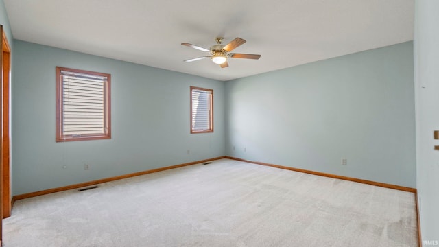 empty room with ceiling fan, carpet, visible vents, and baseboards