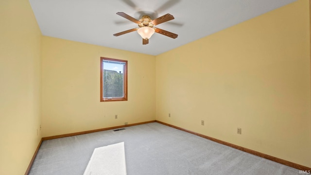 unfurnished room featuring a ceiling fan, visible vents, light carpet, and baseboards