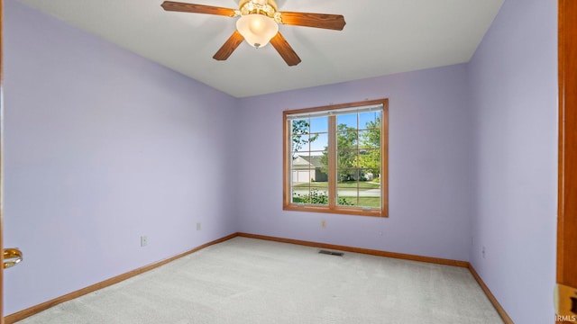 empty room featuring baseboards, visible vents, a ceiling fan, and light colored carpet