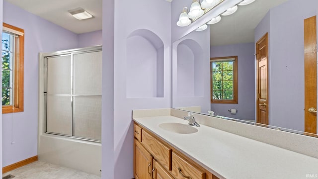 full bathroom featuring baseboards, shower / bath combination with glass door, tile patterned flooring, vanity, and a notable chandelier