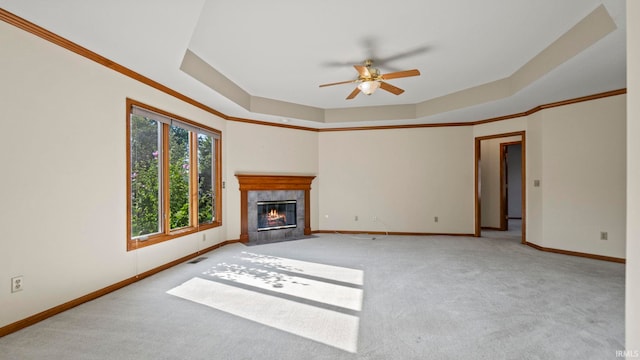 unfurnished living room featuring a tray ceiling, carpet, a fireplace, visible vents, and baseboards