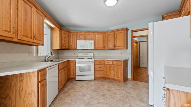 kitchen featuring light countertops, white appliances, a sink, and decorative backsplash