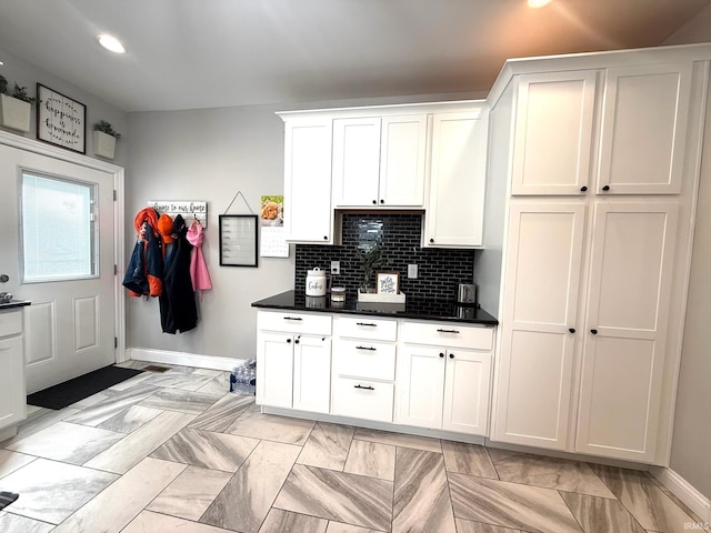 kitchen featuring dark countertops, recessed lighting, backsplash, white cabinetry, and baseboards