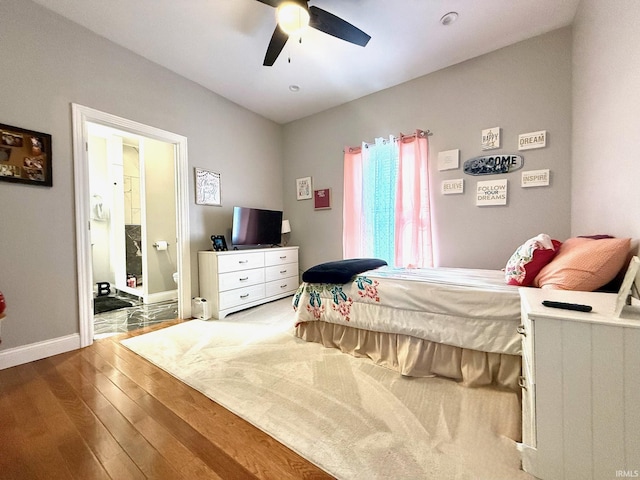 bedroom with connected bathroom, wood-type flooring, ceiling fan, and baseboards