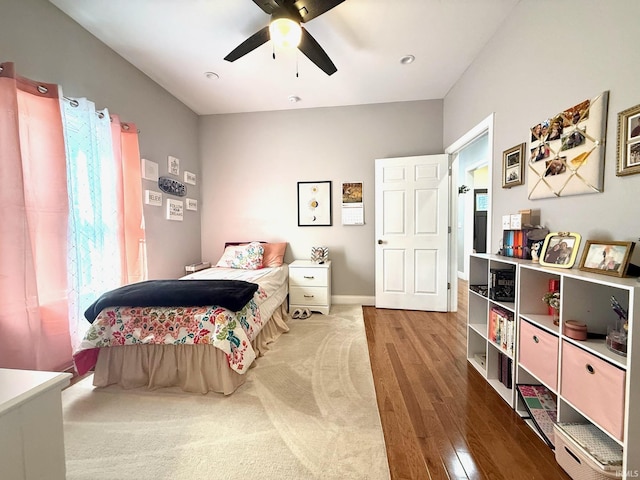 bedroom with a ceiling fan, baseboards, and wood finished floors