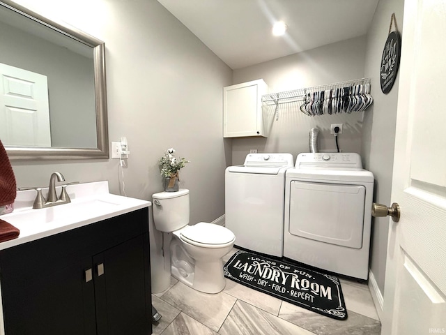 half bathroom featuring independent washer and dryer, vanity, and toilet