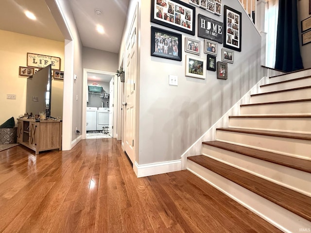 corridor with baseboards, stairway, washing machine and clothes dryer, and wood finished floors