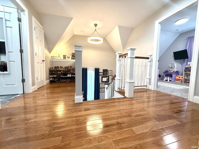 foyer featuring lofted ceiling, hardwood / wood-style floors, and baseboards