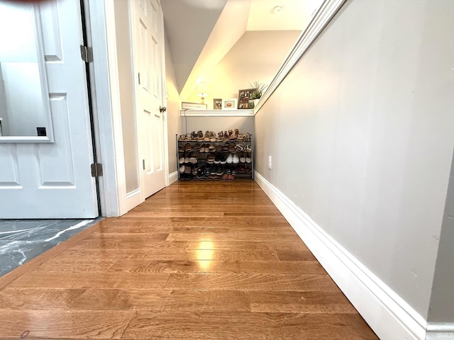 corridor featuring baseboards and wood finished floors