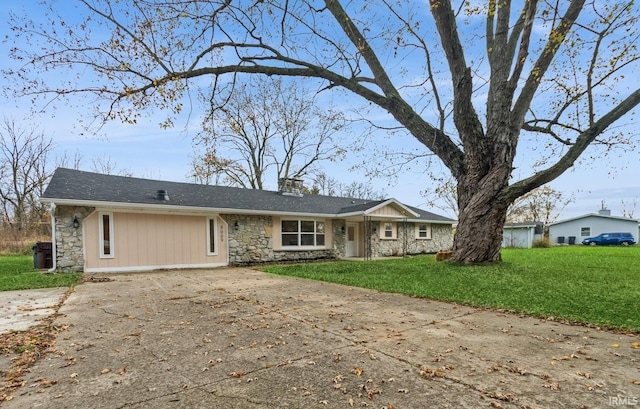 ranch-style house with stone siding, a front lawn, a chimney, and concrete driveway