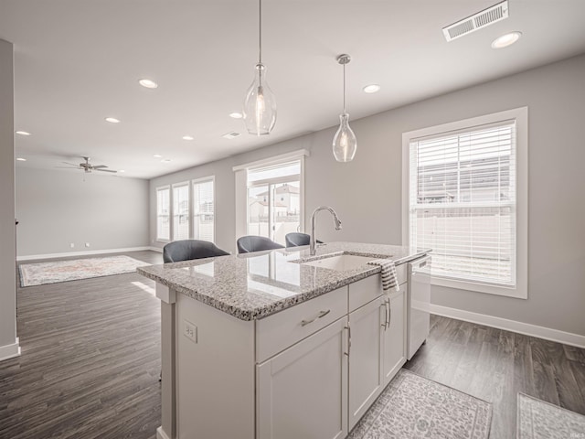 kitchen with visible vents, dishwasher, dark wood-type flooring, hanging light fixtures, and a sink