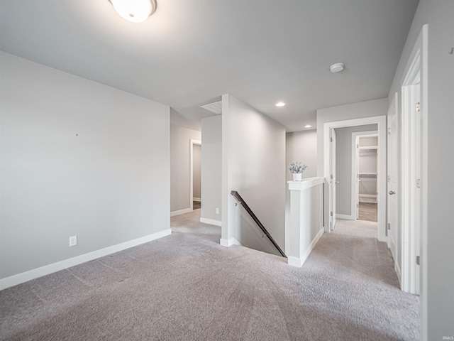 hallway featuring carpet, baseboards, an upstairs landing, and recessed lighting