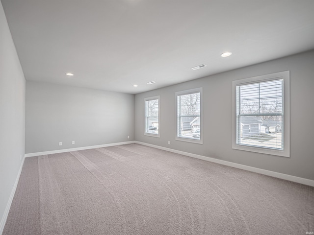 spare room with light carpet, baseboards, and recessed lighting