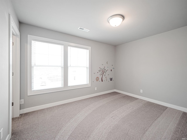 spare room featuring visible vents, baseboards, and carpet flooring