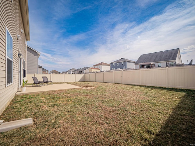 view of yard with a patio area, fence, and a residential view