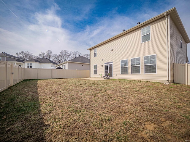 back of property featuring a patio area, a fenced backyard, and a lawn