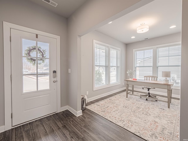 doorway featuring dark wood-style flooring, visible vents, and baseboards