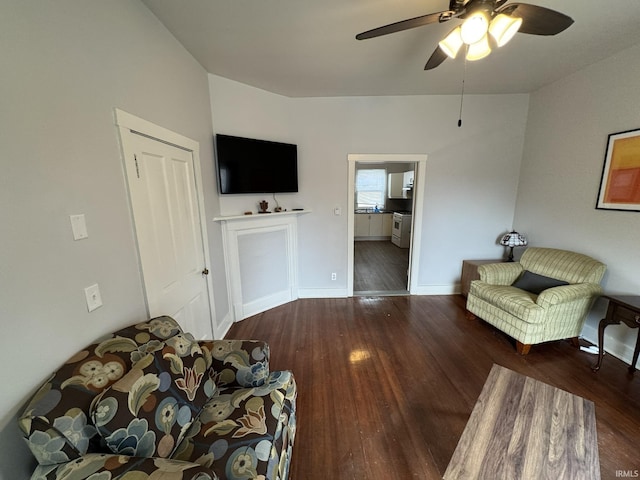 living room featuring ceiling fan, baseboards, and wood finished floors