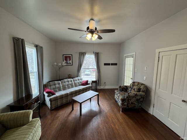 living area with ceiling fan, baseboards, and dark wood finished floors