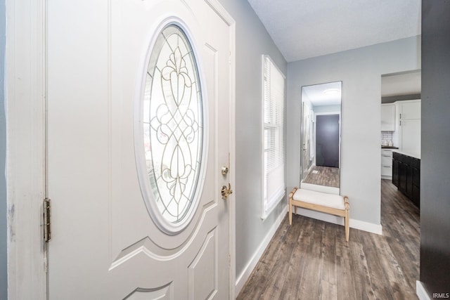 entrance foyer featuring dark wood-style flooring and baseboards