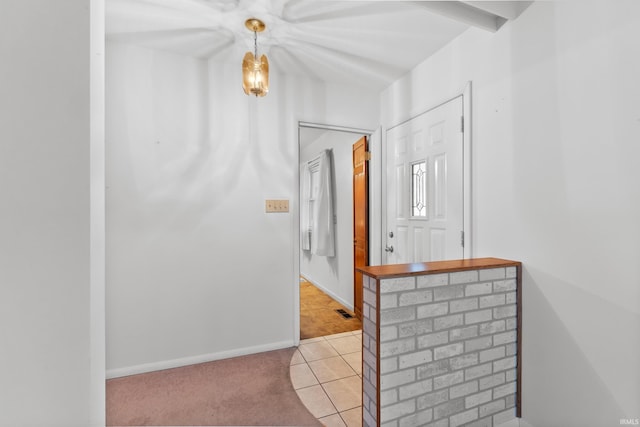 corridor with visible vents, light carpet, baseboards, and light tile patterned floors