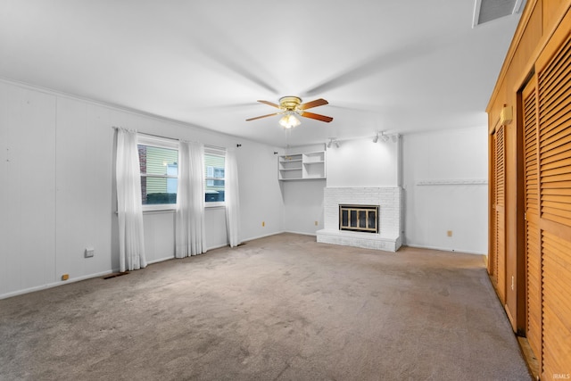 unfurnished living room featuring carpet, visible vents, a fireplace, and ceiling fan