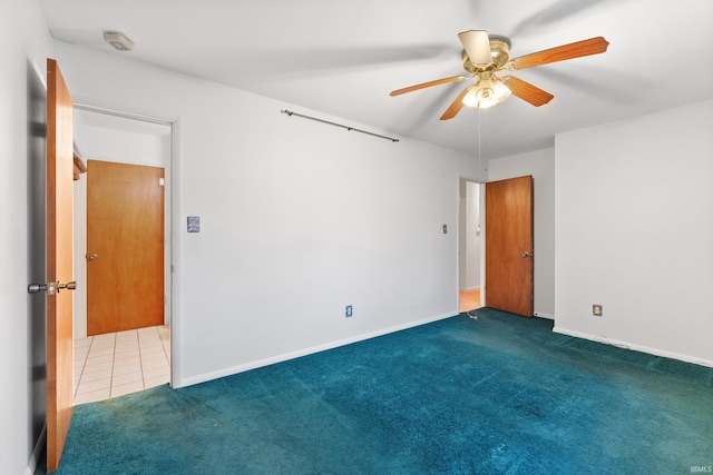 tiled spare room with ceiling fan, baseboards, and carpet flooring