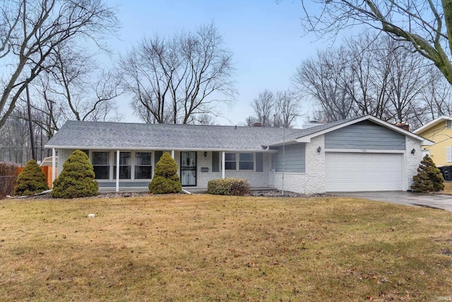 ranch-style home featuring an attached garage, brick siding, driveway, and a front yard