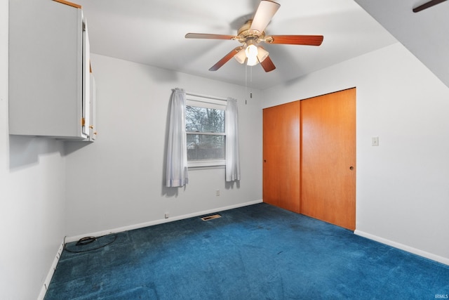 unfurnished bedroom featuring ceiling fan, baseboards, visible vents, and dark colored carpet