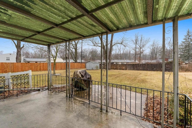 view of patio featuring a shed, grilling area, an outdoor structure, and a fenced backyard