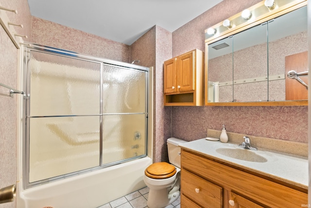 full bathroom featuring toilet, tile patterned flooring, combined bath / shower with glass door, and vanity