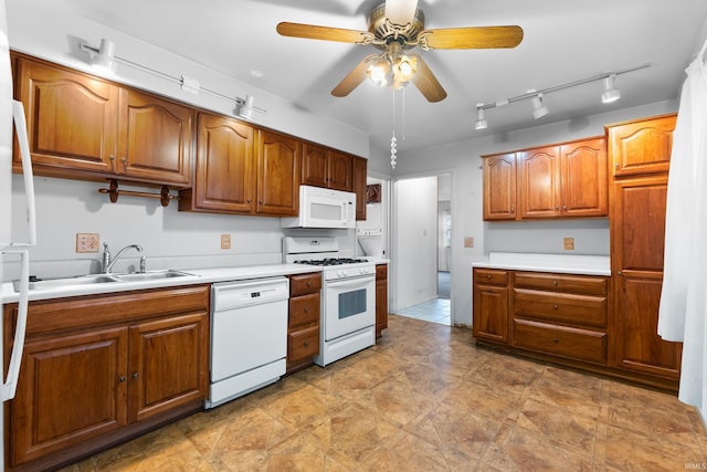 kitchen featuring white appliances, a sink, and brown cabinets