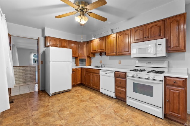 kitchen with light countertops, visible vents, brown cabinetry, a sink, and white appliances