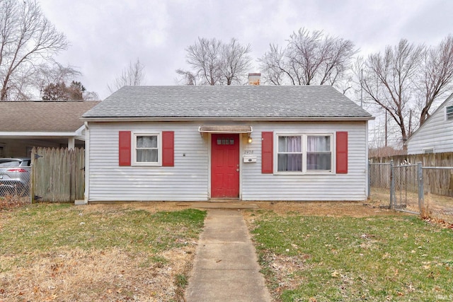 bungalow-style home featuring roof with shingles, a front yard, and fence