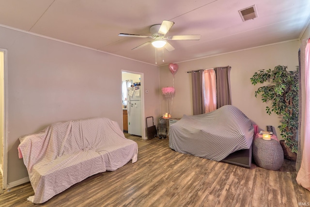 bedroom featuring wood finished floors, visible vents, and crown molding