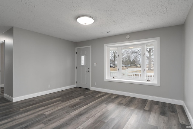 entryway with dark wood-style floors, a textured ceiling, and baseboards