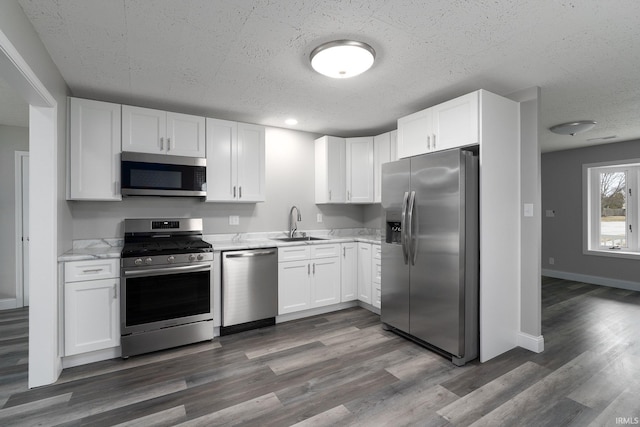 kitchen featuring appliances with stainless steel finishes, a sink, and white cabinetry