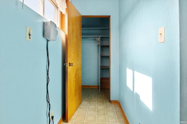 hall with light tile patterned floors and baseboards