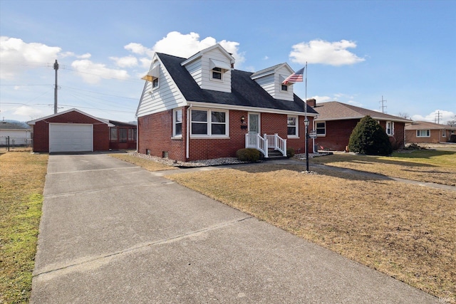 cape cod-style house with a garage, brick siding, an outdoor structure, driveway, and a front lawn