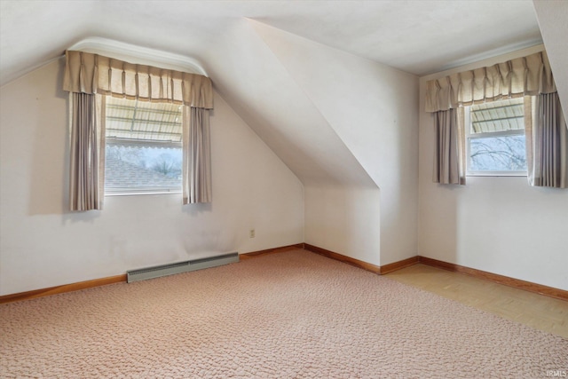 additional living space with lofted ceiling, a baseboard radiator, and baseboards