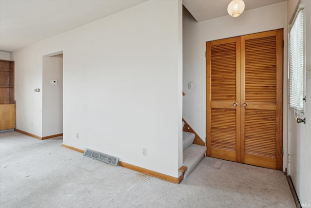 unfurnished bedroom featuring baseboards, a closet, visible vents, and carpet flooring